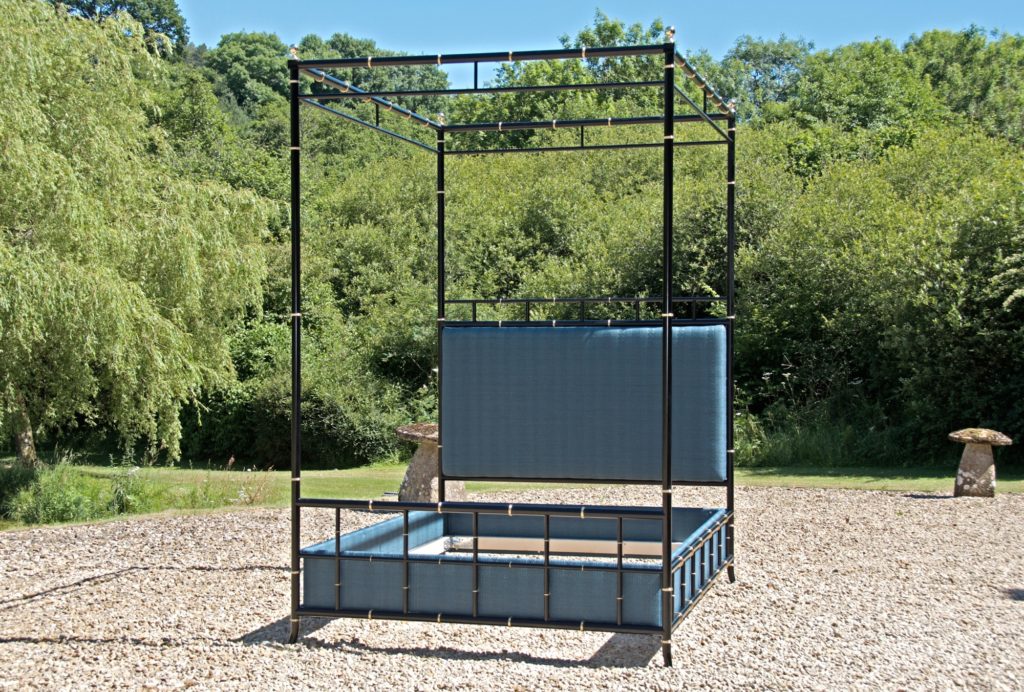 A black Four-Poster Bed frame with blue panels