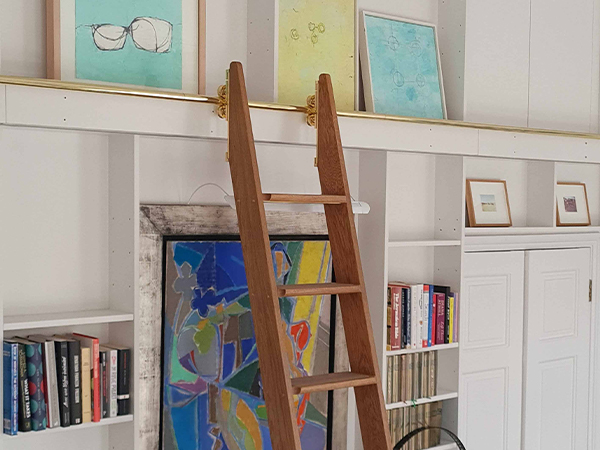 Custom rolling and retractable library ladder by Andrew Nebbett Designs