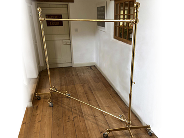 Polished brass adjustable clothes rail by Andrew Nebbett Designs