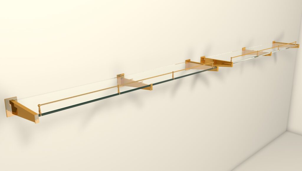 A long glass shelf with brass brackets is mounted on a white wall. The shelf has multiple sections and appears both modern and minimalist in design. Shadows of the shelf fall on the wall beneath it.