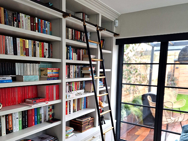 Hand-patinated brass and gun barrel steel library ladder and rails by Andrew Nebbett Designs